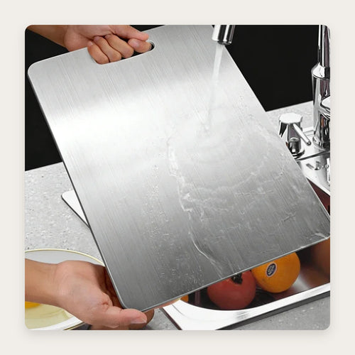 Tagliere in acciaio inox sciacquato sotto il rubinetto
